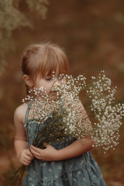 Girl in denim dress with baby's  breath by Lawrenceville Child Photographer