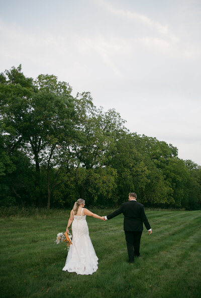 Wedding couple walking along forest at The Eloise