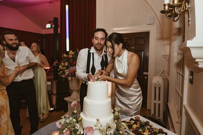 bride and groom cut pieces of their funfetti cake