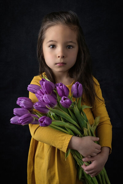 Child holds tulip flowers for fine art studio photos in Mount Holly, New Jersey