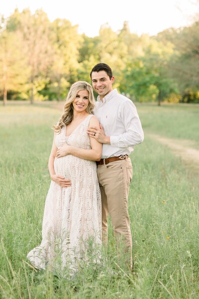 a pregnant woman standing with her husband