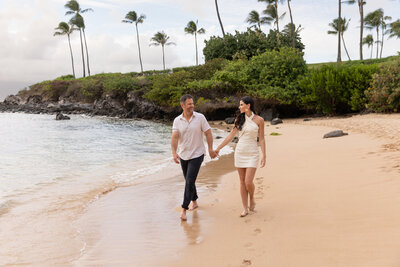 Maui Family Photographers capture man and woman holding hands along the beach