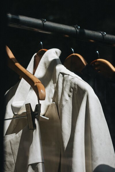 Clothing hanging on a garment rack with wooden hangers
