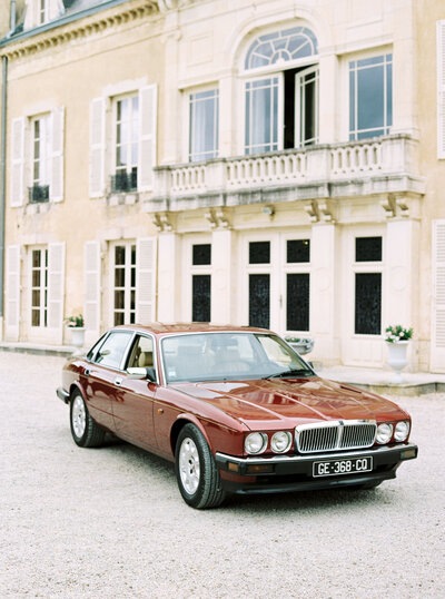 Vintage car parked outside chateau
