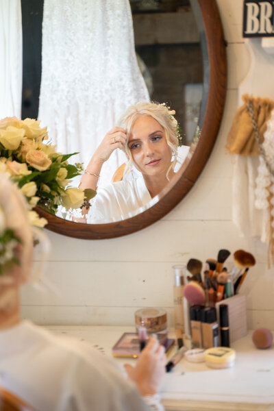 Cleveland area bride, Jessica Cox, finishing up her wedding makeup in front of a mirror at Peacock Ridge.