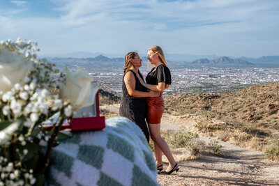 gay women embrace with engagement ring