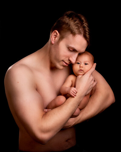 Heartwarming father and newborn portrait session in Prairie Village, Kansas. Ideal for families planning milestone or maternity photography.