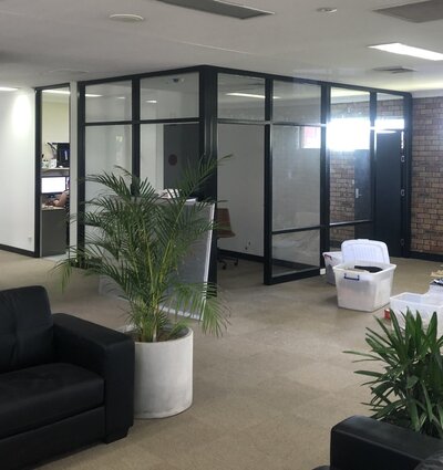 Custom glass partitions for commercial spaces, designed for a professional and open office layout.