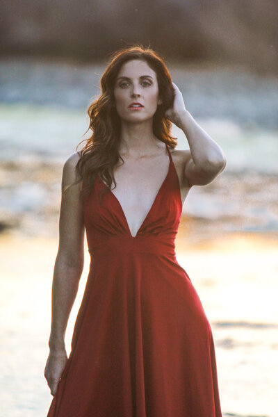 Red Dress Model on beach during sunste