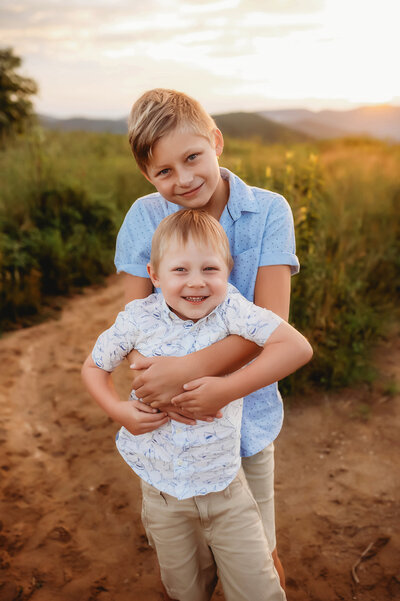 Brothers hug during Blue Ridge Parkway, mountain top family photoshoot in Charleston, SC.