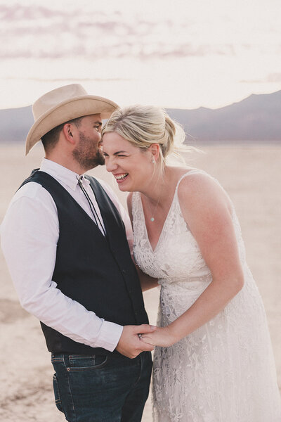 bride and groom laugh after elopement in las vegas desert