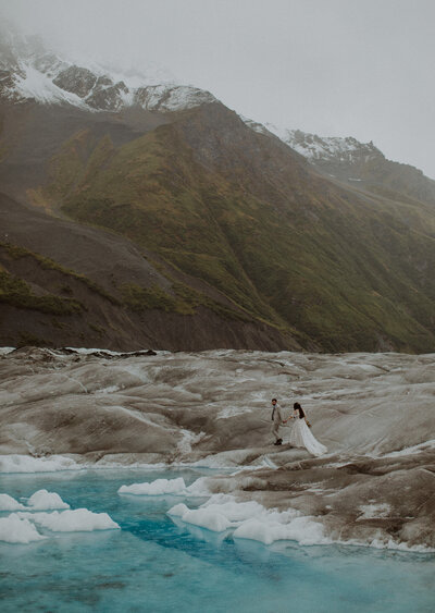 Couple walks along the glacial ice in Alaska on their elopement day.