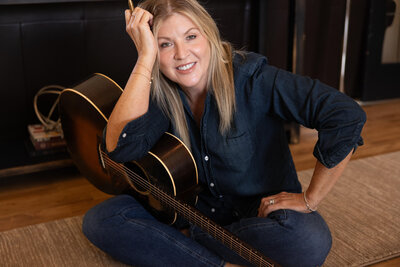 Amy Hailstone with Acoustic Guitar and Pen. Vocal Coaching and Guitar Lessons