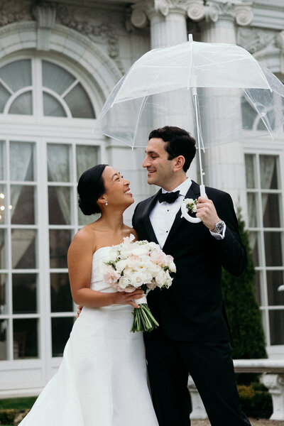 Vermont Wedding Photographer | Sincerely Liz Photography Documentary Wedding, Engagement, Elopement, Maternity and Newborn Photographer in New England | Bride and groom smiling at each other while holding an umbrella