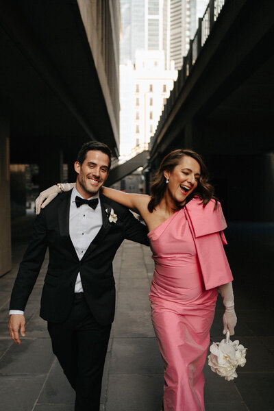 bride in pink dress laughing with her groom after wedding ceremony