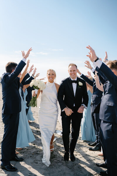 Bride and groom running through their bridal party at Cape May New Jersey wedding