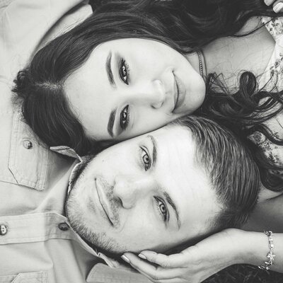 Close up black and white portrait of couple with cheeks pressed together