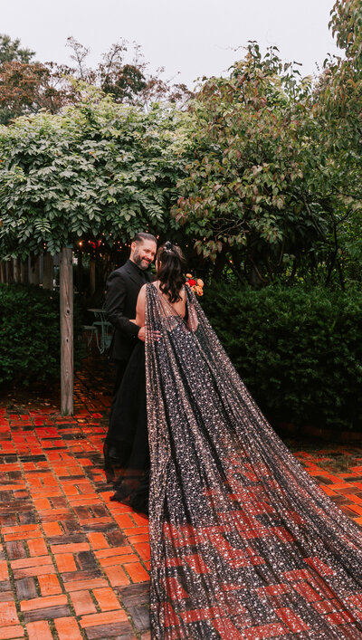 Alternative bride and groom in black wedding attire posing at House of the Seven Gables