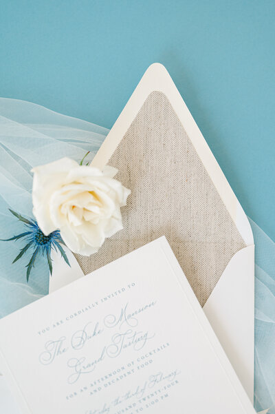 Classic envelope liner with a book cloth texture, invitation with embossed border