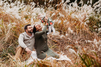 couple and baby walking in wooded park
