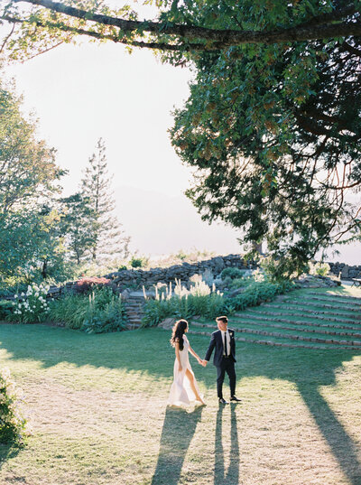 bride and groom walking at the griffin house at sunset