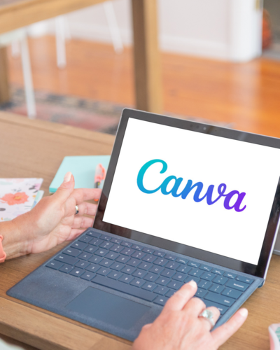 A person working on a laptop with Canva display on the screen.
