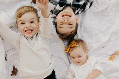 Three children on blanket during photo shoot