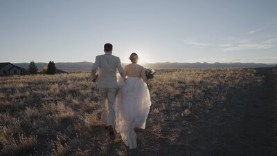 The couple is running towards the sunset on a wide field after they just got married. Filmed by Jimmy Shin Films