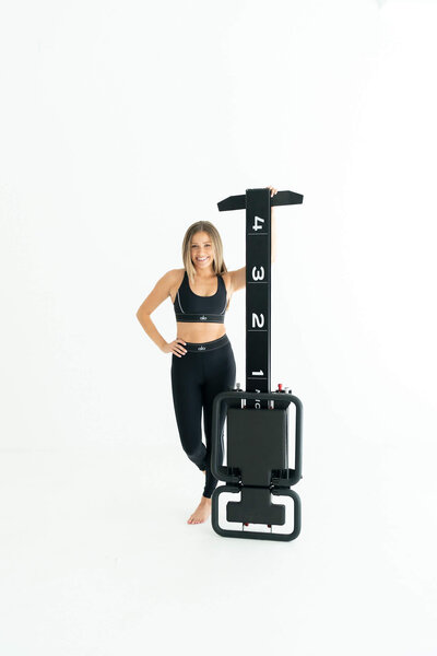 kylie smiling holding onto reformer standing up