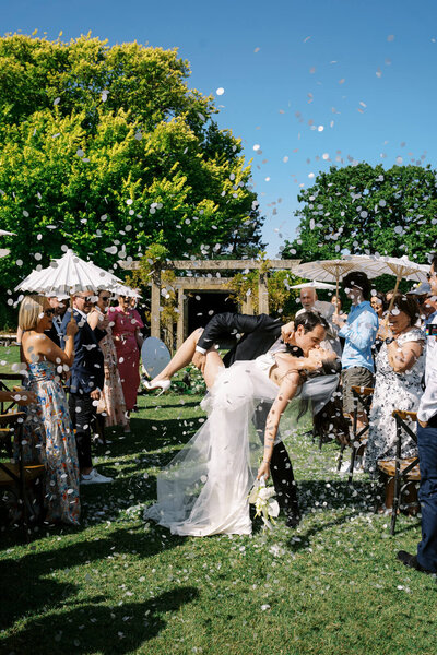 bride and groom hugging with confetti falling