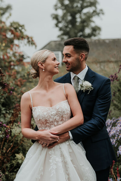 Elegant Bride & Groom  surrounded by summer florals at Bury Court Barn