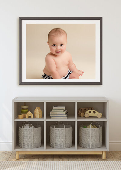 Framed photo of a smiling baby sitting up.