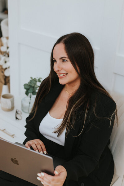 Photo of a girl with a laptop posing in a branding photography photoshoot with La Luz Studios