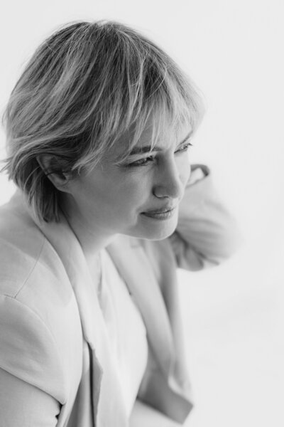 Portretfoto van Rosanne van Cruijningen, redacteur en schrijfcoach voor romanschrijvers, starend in de verte.