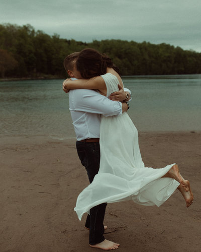 Groom picks up bride and kisses her after their elopement at Green Lakes State Park in Syracuse, NY