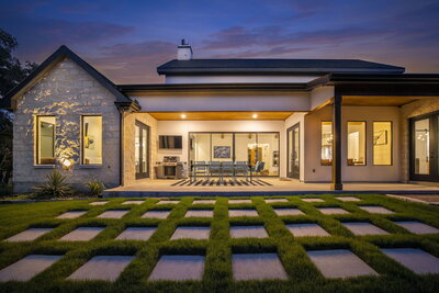 limestone house with modern pavers in backyard