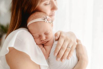 Mother embraces her infant during Newborn Portrait Session in Charleston, SC.