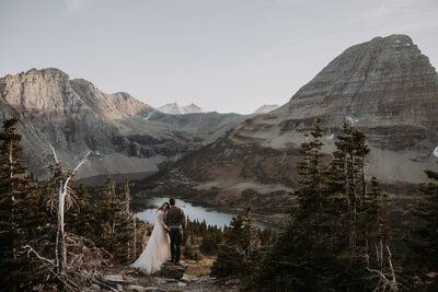couple standing on rocks on the beach