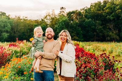 family of 3 smiling at camera outdoors by Philadelphia Family Photographer