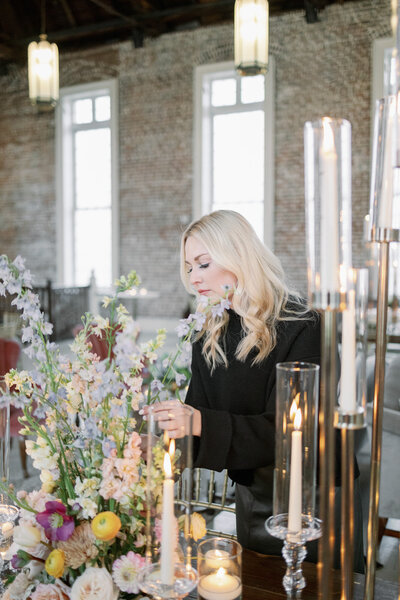 Natasha Kozlowski, luxury wedding planner in Austin and New Orleans, arranging florals at luxury wedding reception