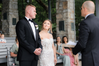 A bride looks at her groom with teary eyes and a smile during their wedding ceremony at Pretty Place Chapel in Greenville SC.