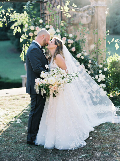 A bride and groom kiss passionately.