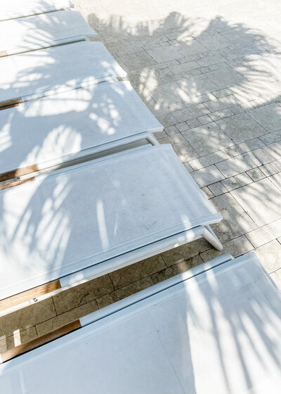 Lounge chairs with palm tree shadow