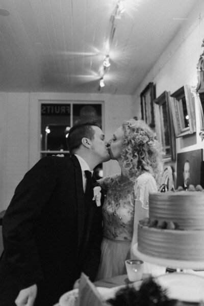 Bride and groom smiling and embracing after cutting their wedding cake during an intimate backyard reception in Richmond, Virginia.