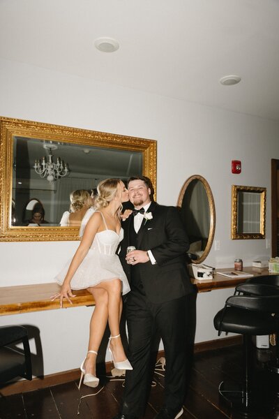 flash photography bride kissing grooms cheek