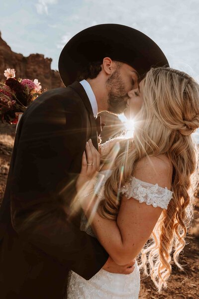groom with cowboy hat kissing bride