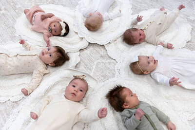 Group of babies arranged in a circle on the floor