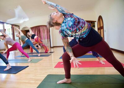 Wide legged forward fold demonstration during vinyasa yoga teacher training California