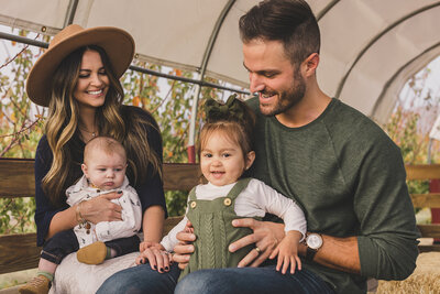 mom and dad hold their children for a family photo in las vegas