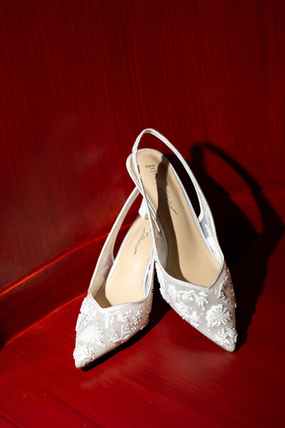 high-end bridal photos with bride sitting on chair and groom standing behind her